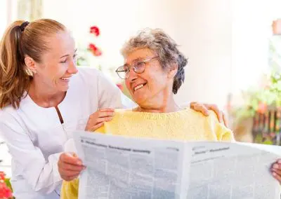senior woman and daughter reading newspaper