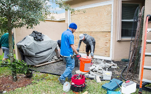 Two construction workers are preparing for the installation of a impact resistant sliding glass door in a Florida home. They have boarded up the outside wall of the home where the door will be installed. The glass is recommended in hurricane prone areas. Taken with Canon 5D Mark III.