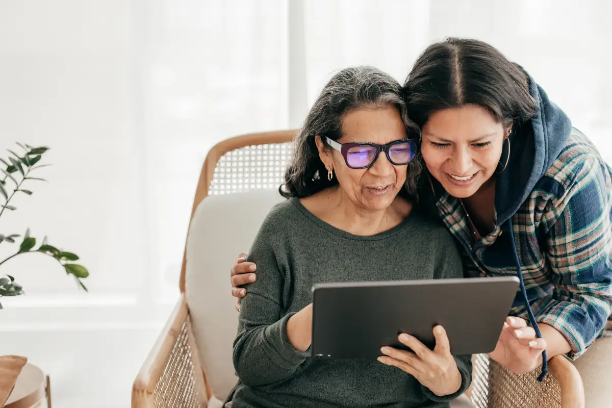 a senior woman and her adult daughter looking at a tablet