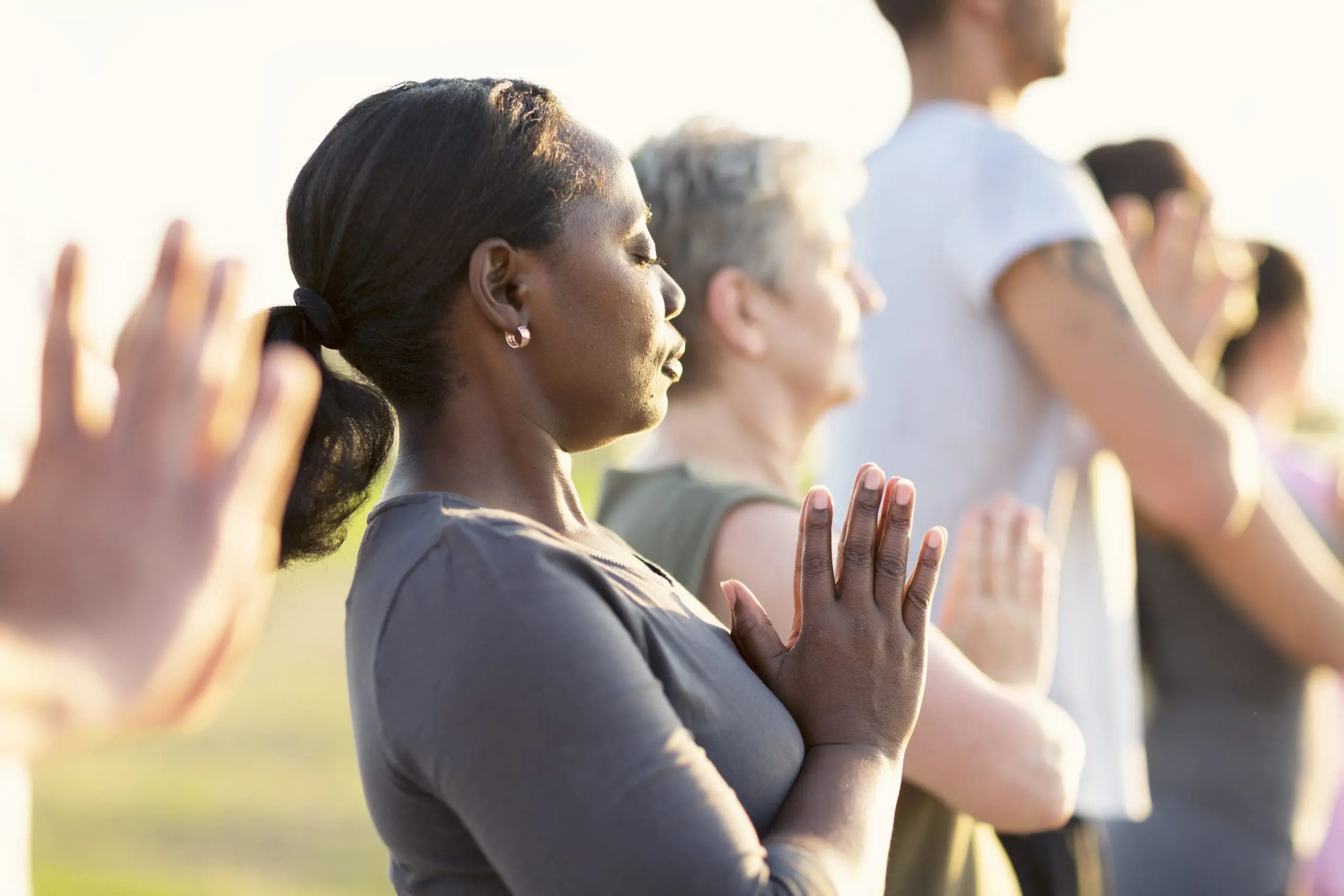 Grupo practicando Yoga al aire libre al atardecer