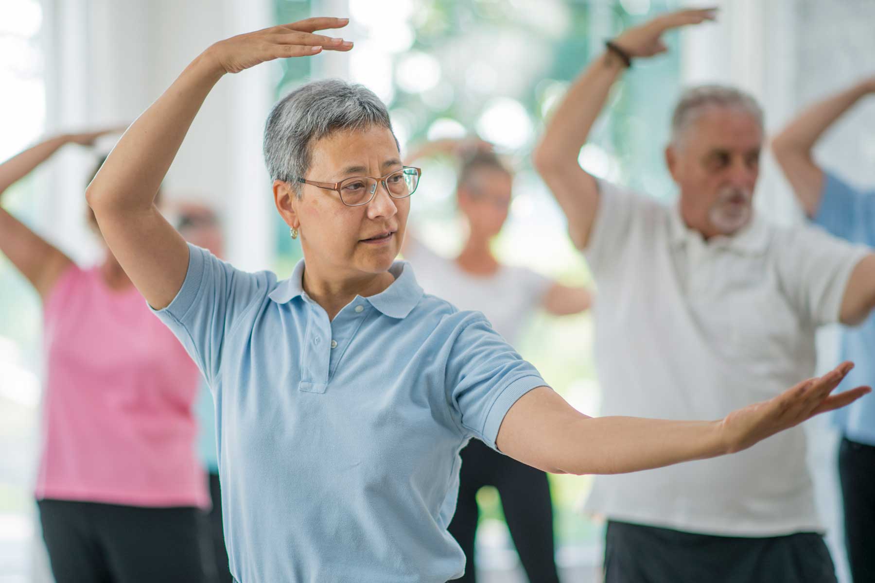 un grupo de personas mayores participando en una clase de Tai Chi