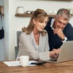 senior couple looking at the tax benefits of retirement communities on their computer